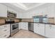 Well-lit kitchen features stainless steel appliances, light cabinetry, and tile backsplash at 7520 Sunshine Skyway S Ln # 110, St Petersburg, FL 33711