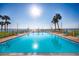 Community pool with crystal blue water, chairs for lounging and swaying palm trees at 7520 Sunshine Skyway S Ln # 110, St Petersburg, FL 33711