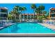 Community pool with crystal blue water, chairs for lounging, and palm trees at 7520 Sunshine Skyway S Ln # 110, St Petersburg, FL 33711