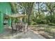 The backyard has a patio with table and chairs and is surrounded by beautiful trees and greenery at 8614 Hibiscus Dr, Tampa, FL 33637