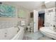Bright bathroom featuring a large tub, unique sink, and adjacent vanity with decor at 8614 Hibiscus Dr, Tampa, FL 33637