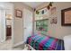 Small bedroom with unique decorations, light entering from the window, and bathroom door at 8614 Hibiscus Dr, Tampa, FL 33637