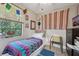 Cozy bedroom features a brightly colored bedspread and eclectic decor for a unique, personalized space at 8614 Hibiscus Dr, Tampa, FL 33637