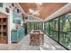 Dining room with decorative wall art, wood ceilings, and expansive windows overlooking lush greenery at 8614 Hibiscus Dr, Tampa, FL 33637