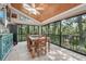 Bright dining room with wood ceilings, natural light, and views of the surrounding greenery at 8614 Hibiscus Dr, Tampa, FL 33637