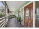 Charming covered front porch with seating area, wooden floors, and a wooden front door at 8614 Hibiscus Dr, Tampa, FL 33637