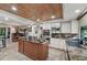 Bright kitchen with a stone island, stainless steel appliances, wooden ceiling, tile flooring, and natural light at 8614 Hibiscus Dr, Tampa, FL 33637