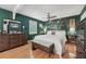 Bright bedroom with hardwood floors, ceiling fan, and elegant tropical-themed accent wall at 8614 Hibiscus Dr, Tampa, FL 33637