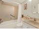 Bright bathroom featuring a bathtub with shower, white vanity, and light-colored tile at 9 Haig Pl # 510, Dunedin, FL 34698