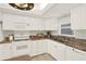 Well-lit kitchen featuring a clean design with modern appliances, granite countertops, and white cabinetry at 9 Haig Pl # 510, Dunedin, FL 34698