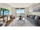 Bright living room featuring a sliding door to a balcony with water views, modern furnishings, and a neutral color palette at 9 Haig Pl # 510, Dunedin, FL 34698