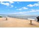 Outdoor patio area with tables, chairs, a waterfront view, and a clear blue sky at 9 Haig Pl # 510, Dunedin, FL 34698