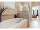 Bright bathroom featuring a luxurious soaking tub and glass-enclosed shower with elegant tile accents at 10617 Lucaya Dr, Tampa, FL 33647