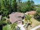 Aerial view of a home with a well-manicured lawn and mature trees, highlighting its serene location at 1135 Wyndham Lakes Dr, Odessa, FL 33556