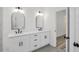 Elegant bathroom with dual vanities, sleek white cabinets, and modern fixtures near doorway at 1135 Wyndham Lakes Dr, Odessa, FL 33556