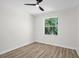 Bright bedroom with ceiling fan features wood-look flooring and ample natural light from the window at 1135 Wyndham Lakes Dr, Odessa, FL 33556