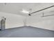 Spacious, well-lit garage with light gray epoxy flooring and overhead door with operating hardware at 1135 Wyndham Lakes Dr, Odessa, FL 33556
