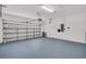 Well-lit garage featuring light gray epoxy flooring and an automatic overhead door at 1135 Wyndham Lakes Dr, Odessa, FL 33556