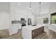 Modern kitchen boasts white cabinets, stainless appliances, and a central island with pendant lights at 1135 Wyndham Lakes Dr, Odessa, FL 33556