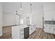 Open-concept kitchen with stainless steel appliances, waterfall island, and luxury vinyl plank floors at 1135 Wyndham Lakes Dr, Odessa, FL 33556
