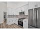 Bright kitchen features stainless steel appliances, stylish backsplash and white cabinets at 1135 Wyndham Lakes Dr, Odessa, FL 33556