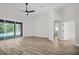 Open-concept living space with wood floors, ceiling fan, and sliding doors to a screened-in pool at 1135 Wyndham Lakes Dr, Odessa, FL 33556