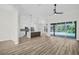 A spacious living room with wood floors opens to a modern kitchen and screened-in pool area at 1135 Wyndham Lakes Dr, Odessa, FL 33556