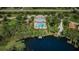 Aerial view of community featuring clubhouse, pool, tennis court, and lake access at 11833 Castine St, New Port Richey, FL 34654