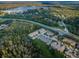 Aerial view of multi-Gathering homes, large trees, lake, and a road with cars at 11833 Castine St, New Port Richey, FL 34654