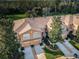 Aerial view of a tan townhome complex featuring attached garages, manicured landscaping and mature trees at 11833 Castine St, New Port Richey, FL 34654