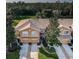 Aerial view of a tan townhome complex featuring attached garages, manicured landscaping and mature trees at 11833 Castine St, New Port Richey, FL 34654