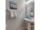 Powder room features a pedestal sink, decorative mirror, and stylish fixtures at 11833 Castine St, New Port Richey, FL 34654