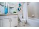 Bright bathroom featuring a tiled shower and tub, and a vanity with storage at 11833 Castine St, New Port Richey, FL 34654