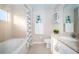 Bright bathroom featuring a tiled shower and tub, and a vanity with storage at 11833 Castine St, New Port Richey, FL 34654