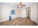Well-lit bedroom with hard wood-look floors, a ceiling fan and ample closet space at 11833 Castine St, New Port Richey, FL 34654