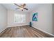 Bedroom with a contemporary ceiling fan, plantation shutters, and wood-look floors at 11833 Castine St, New Port Richey, FL 34654