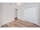 Bedroom featuring wood-look floors, a double door closet, and neutral paint at 11833 Castine St, New Port Richey, FL 34654