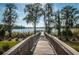 Scenic view of a lake from a wooden dock surrounded by lush vegetation and trees at 11833 Castine St, New Port Richey, FL 34654