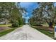 Long driveway leading to a property surrounded by lush greenery and mature trees at 11833 Castine St, New Port Richey, FL 34654