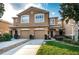 Exterior view of a tan two-story townhome with attached garage, stone accents, and manicured front lawn at 11833 Castine St, New Port Richey, FL 34654