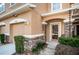 Close-up of front entrance featuring stone-wrapped columns, manicured shrubbery and exterior lighting at 11833 Castine St, New Port Richey, FL 34654