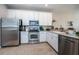 Bright kitchen with stainless steel appliances and white cabinets offers ample counter space at 11833 Castine St, New Port Richey, FL 34654