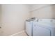 Bright laundry room featuring a washer, a dryer, and a wire shelf at 11833 Castine St, New Port Richey, FL 34654