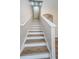 Modern staircase with wood treads and white risers leads to the upper level at 11833 Castine St, New Port Richey, FL 34654