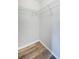 Empty walk-in closet with wood-look flooring and white wire shelving at 11833 Castine St, New Port Richey, FL 34654