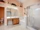 Relaxing bathroom with a glass-enclosed shower, soaking tub, vanity, and peach colored walls at 12322 Hawkeye Point Pl, Riverview, FL 33578