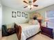 Charming bedroom featuring a ceiling fan, a fan, decorative wall art, and a comfortable bed at 12322 Hawkeye Point Pl, Riverview, FL 33578