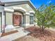 Inviting front entrance with a welcoming pink door, decorative wreath, and neat landscaping at 12322 Hawkeye Point Pl, Riverview, FL 33578