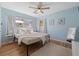 This is a light blue bedroom with hard wood floors, a ceiling fan, and a cozy rug by the bed at 12384 144Th St, Largo, FL 33774