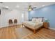 Spacious bedroom featuring hardwood floors, neutral walls, and ceiling fan, alongside a wooden bed with bedside tables at 12384 144Th St, Largo, FL 33774